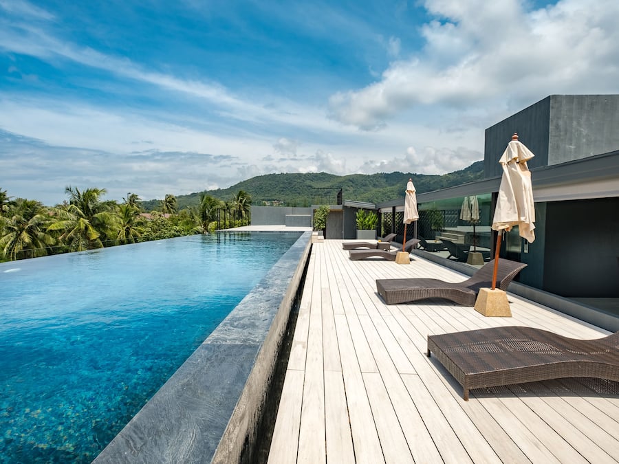 Una piscina al aire libre, sillones reclinables de piscina