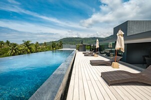 Una piscina al aire libre, sillones reclinables de piscina
