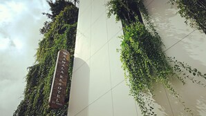 A sign for 'Kamal Resort' with a vertical garden design. - Kamala Resotel (Kamala)