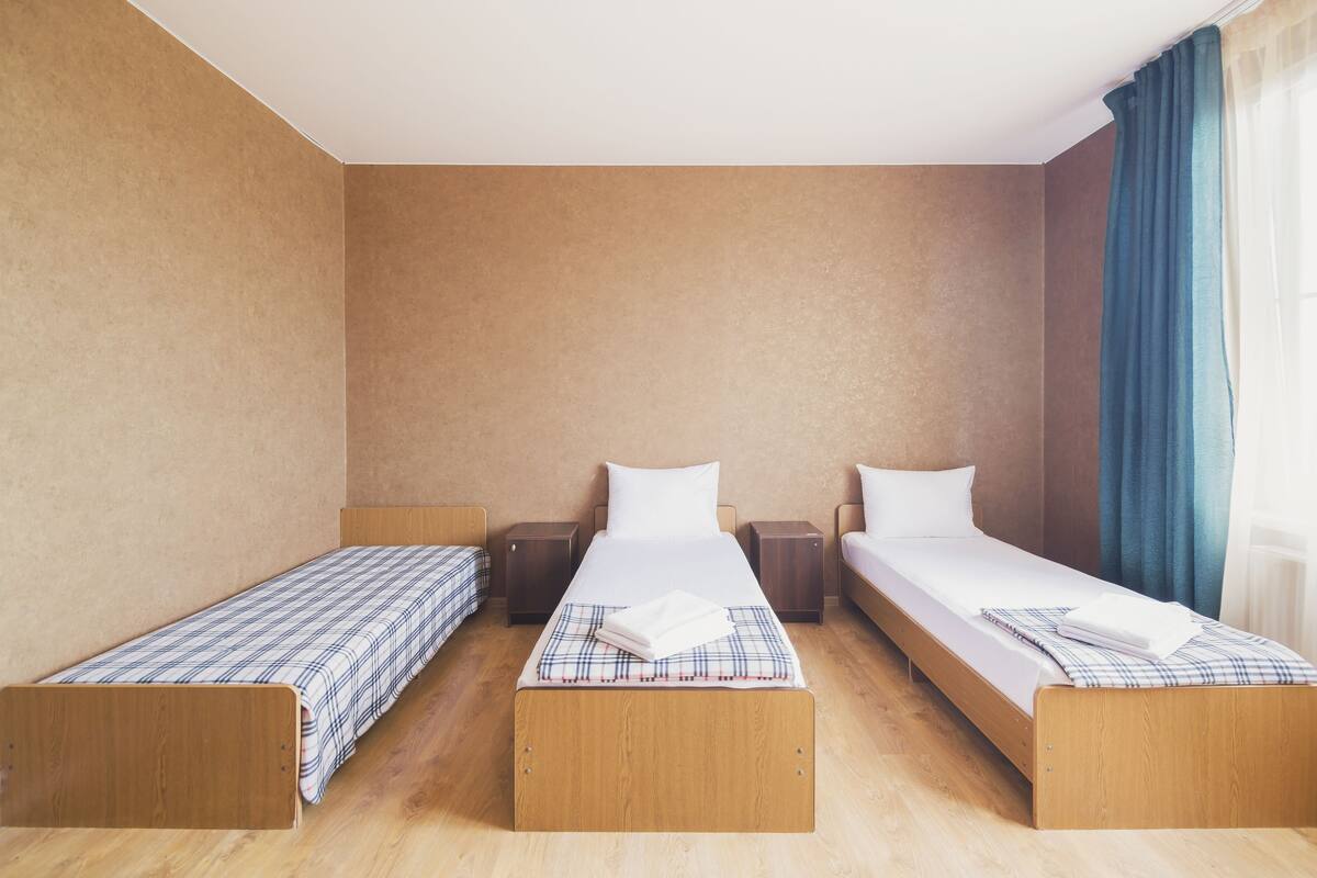 Habitación triple estándar, 3 camas individuales, balcón | Tabla de planchar con plancha, wifi gratis y ropa de cama