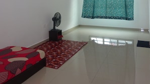 A room with a bed, a standing fan, a window with curtains, and a ceiling fan. - Salam Homestay d'Sendayan (Bandar Sri Sendayan)