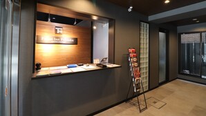 A reception desk with a sign reading "Forest Inn Futuroka" and a magazine rack to the right. - Forest Inn Fukuoka (Fukuoka)