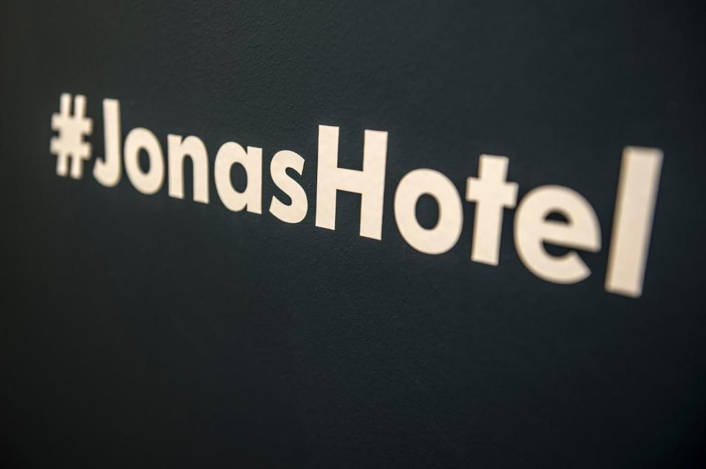 Un senyal amb el text '#JonasHotel' sobre un fons fosc.