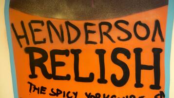 Eine Wand mit Graffiti, auf der 'HENDERSON RELISH THE SPICY YORKSHIRE' steht.