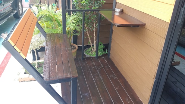 A wooden deck with a bench, potted plants, and a small table. - Paaon Resort Khaoyai (Pak Chong)