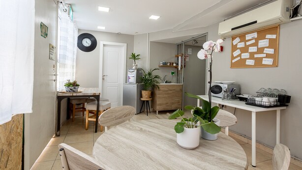 Una cocina moderna con una mesa redonda de madera, sillas y plantas en macetas.