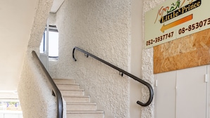 Una escalera con barandilla, un cartel que dice 'Little Prince' con datos de contacto, y una puerta a la derecha.