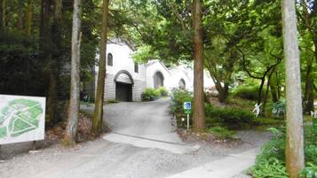 A pathway leading to a building with a stone facade and arched entrance.