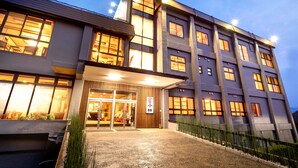 A multi-story hotel with a modern design, featuring a prominent entrance with glass doors and a signboard. - Yumoto Kobayashi (Kurume)
