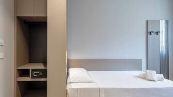 Ein Hotelzimmer mit Bett, Kleiderschrank und Spiegel.