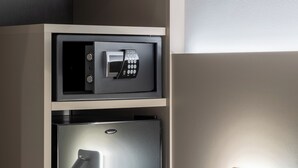 A minibar with a microwave and a mini-fridge, a wall-mounted light switch, and a power outlet. - Hotel Excelsior (Pavia)