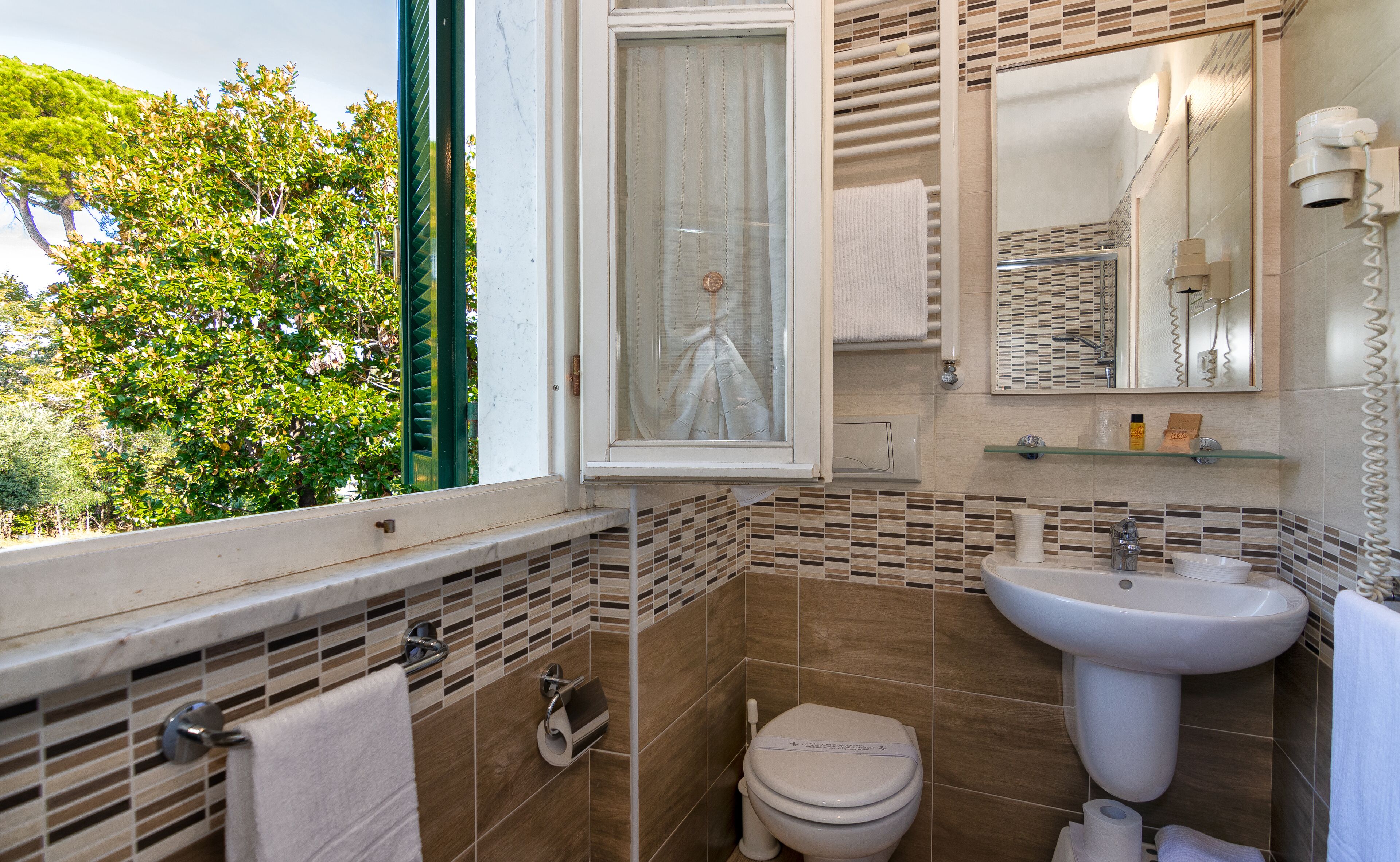 Ein Badezimmer mit Toilette, Waschbecken und Fenster.