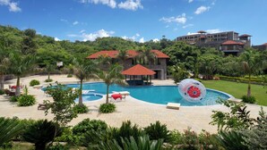 A resort with a large swimming pool, palm trees, and a gazebo. - Mahua Bagh Resort (Kumbhalgarh)