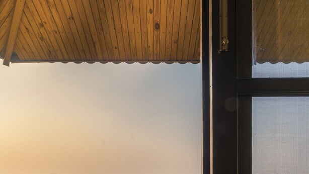 A balcony with wicker chairs and a table, overlooking a mountainous landscape. - Mahua Bagh Resort (Kumbhalgarh)