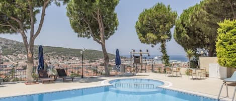 Piscine couverte, piscine extérieure, parasols de plage, chaises longues