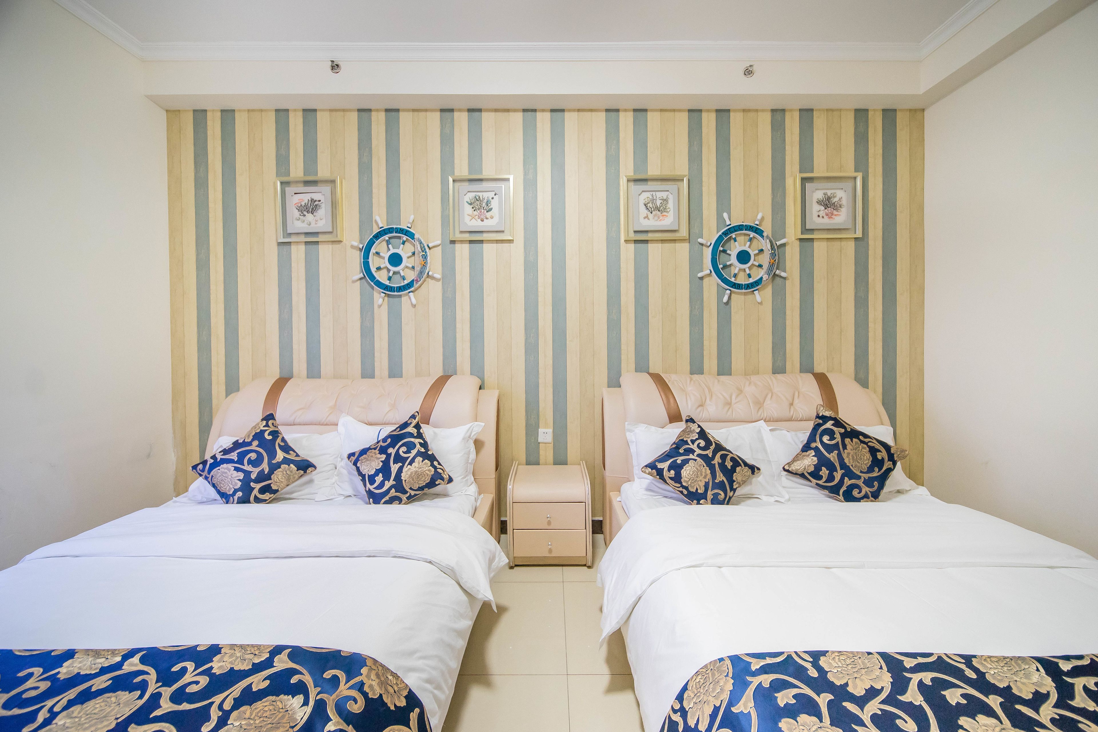 Habitación doble con papel tapiz a rayas, dos mesitas de noche y decoración en la pared.