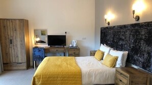A bedroom with a bed, bedside tables, a wardrobe, a television, and wall-mounted lights. - Oxgang Kitchen Bar & Rooms (Grangemouth)
