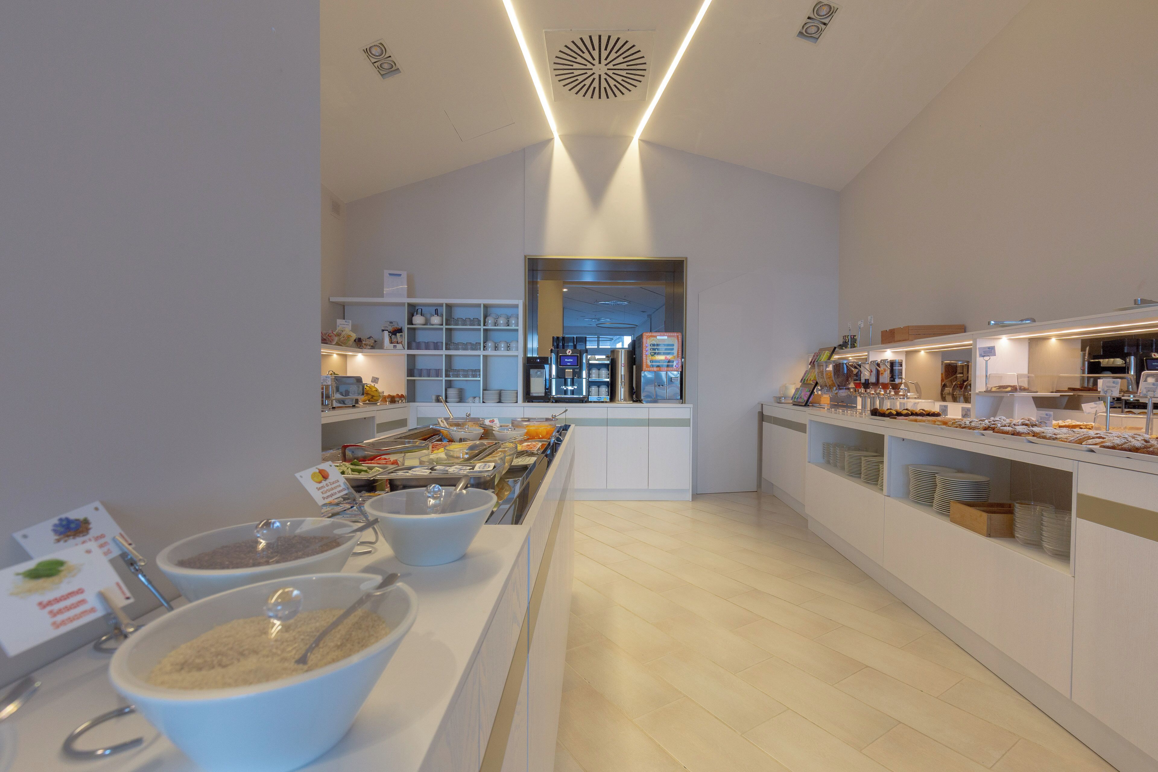 Un espace buffet moderne comprenant différents postes de service et un comptoir central où les plats sont présentés.