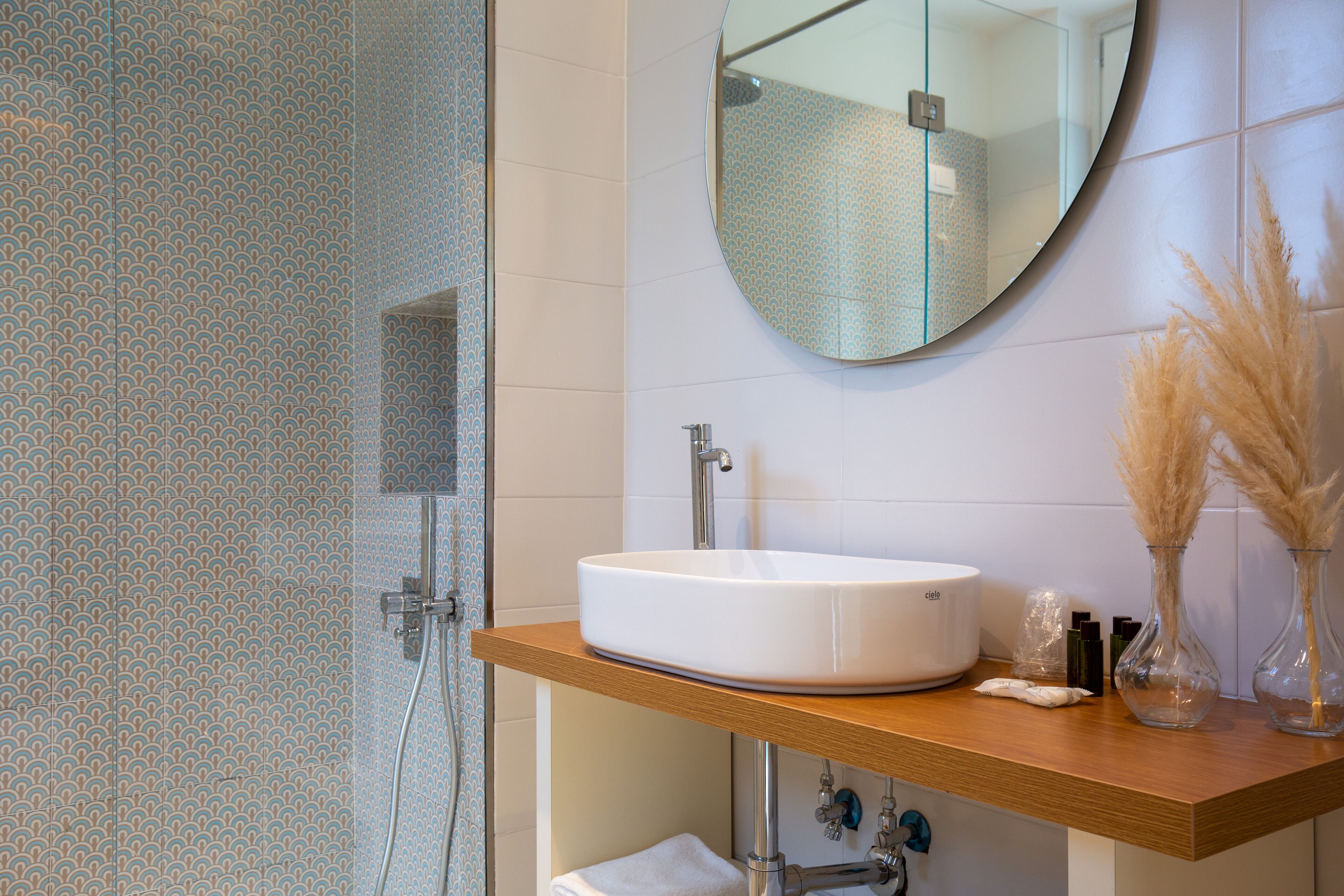 A bathroom with a white sink, a mirror, and a wooden countertop.