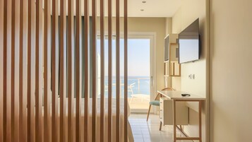 Une chambre d’hôtel moderne dotée d’un balcon, d’un bureau et d’une télévision.