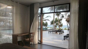 A bedroom with a large window, a desk, and a chair. - Mandala Villas (Rekawa)