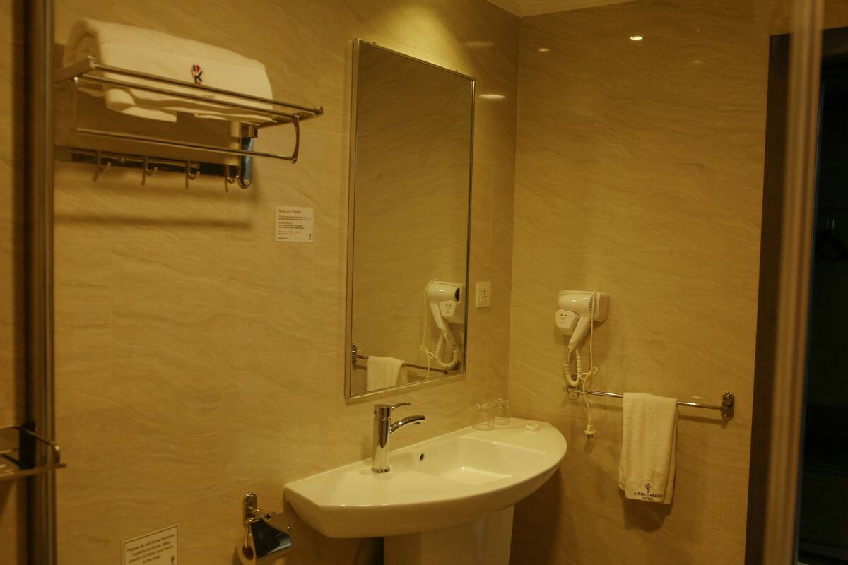 Baño con lavamanos, espejo, toallero y secador de pelo.