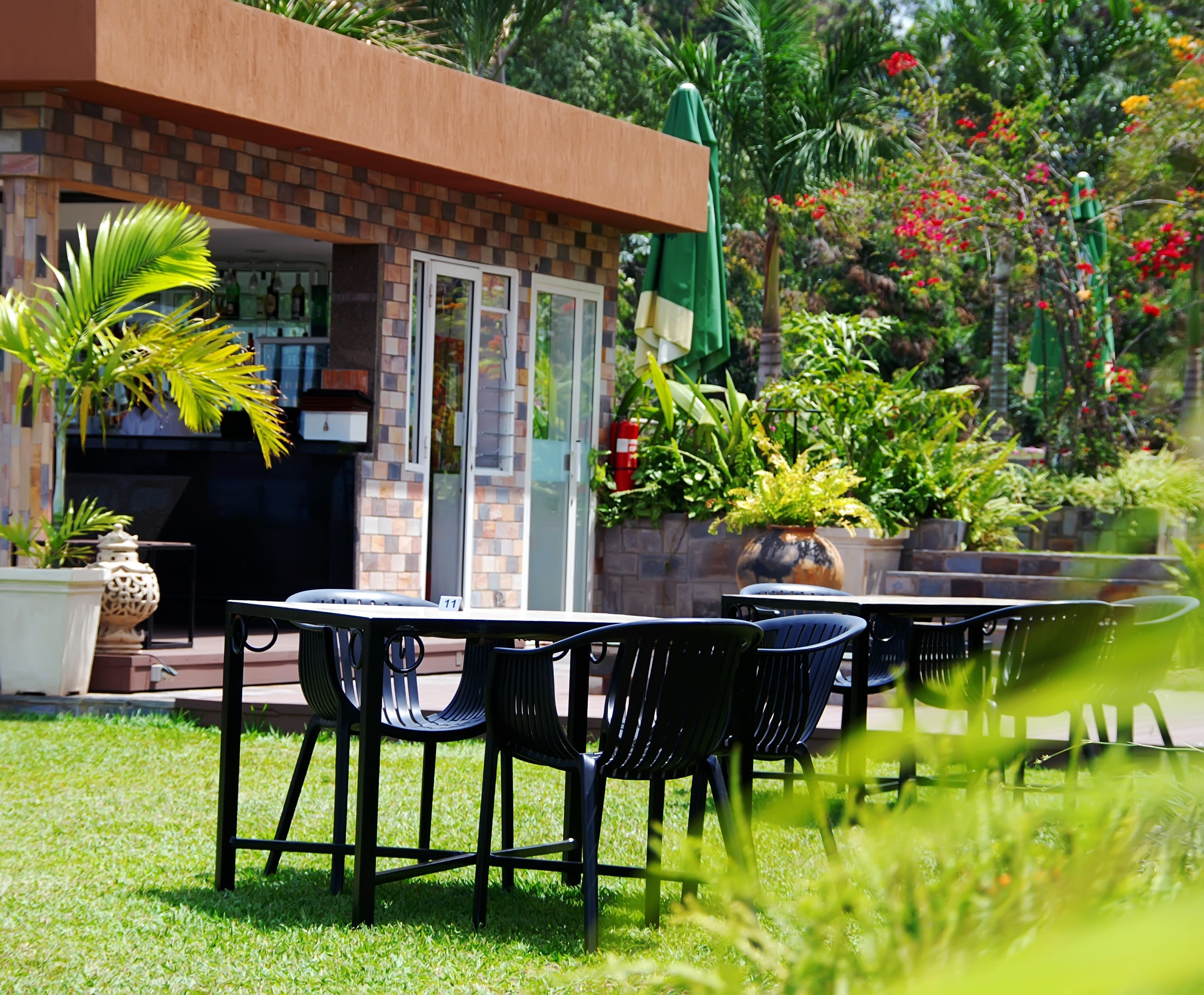 A patio area with a brick wall, outdoor seating, and potted plants.