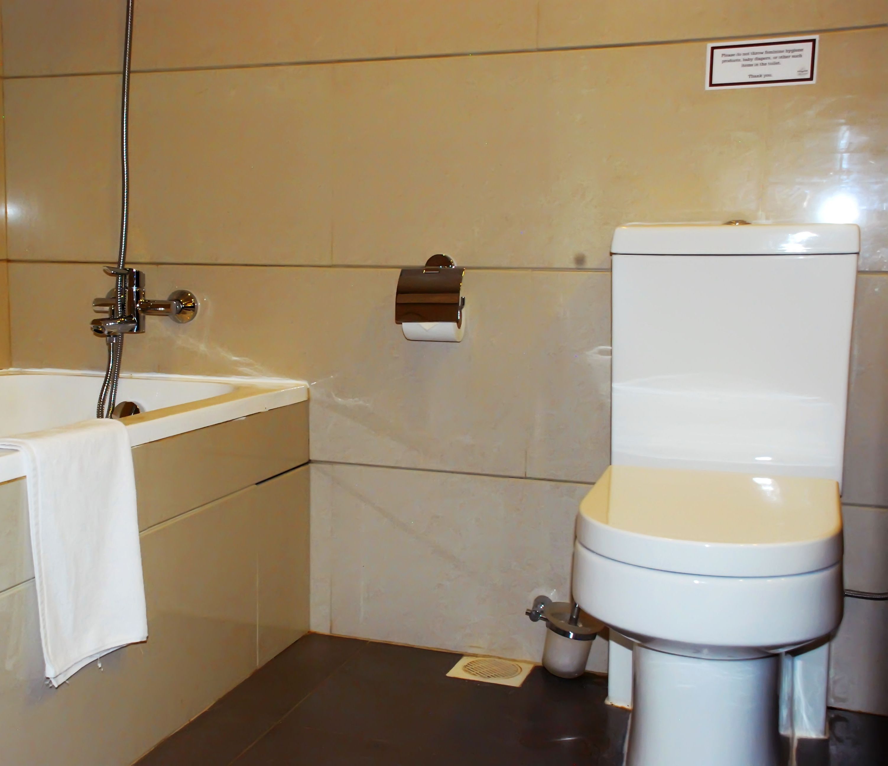 Ein Badezimmer mit Badewanne, Toilette und einem Händetrockner.