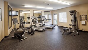A gym with treadmills, elliptical machines, and weight equipment.