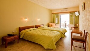 Een slaapkamer met twee bedden, een houten nachtkastje, een stoel en een tafel.