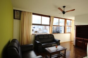 Una sala de estar con sofá, mesa de centro y ventilador de techo.