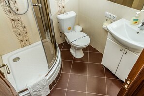 Une salle de bain équipée d’une douche, de toilettes, d’un lavabo et d’une cabine de douche en verre.