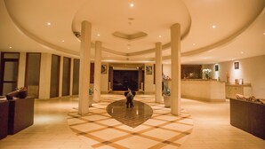 A spacious lobby with a checkered floor, large columns, and a reception desk. - Nyali Beach Holiday Resort (Mombasa)