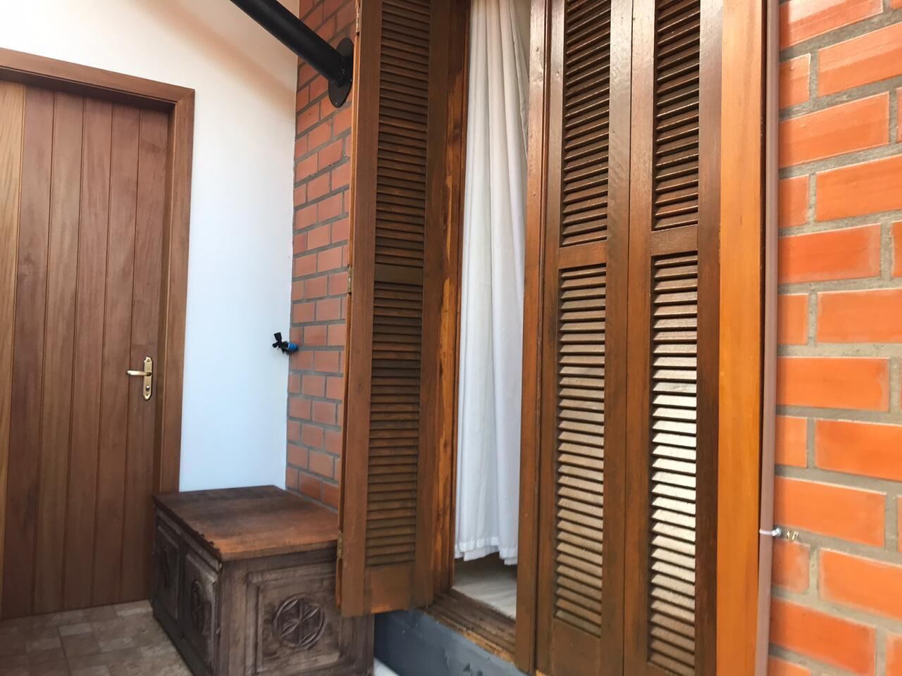 A wooden door, a brick wall, and wooden shutters.