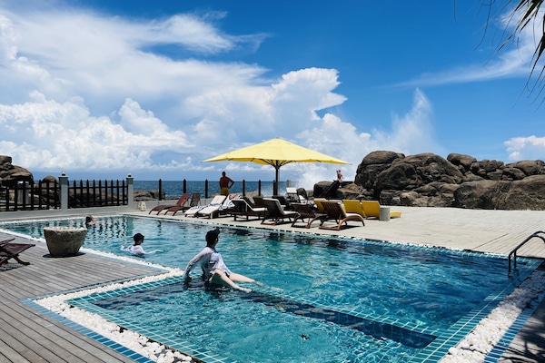 Una piscina al aire libre, tumbonas