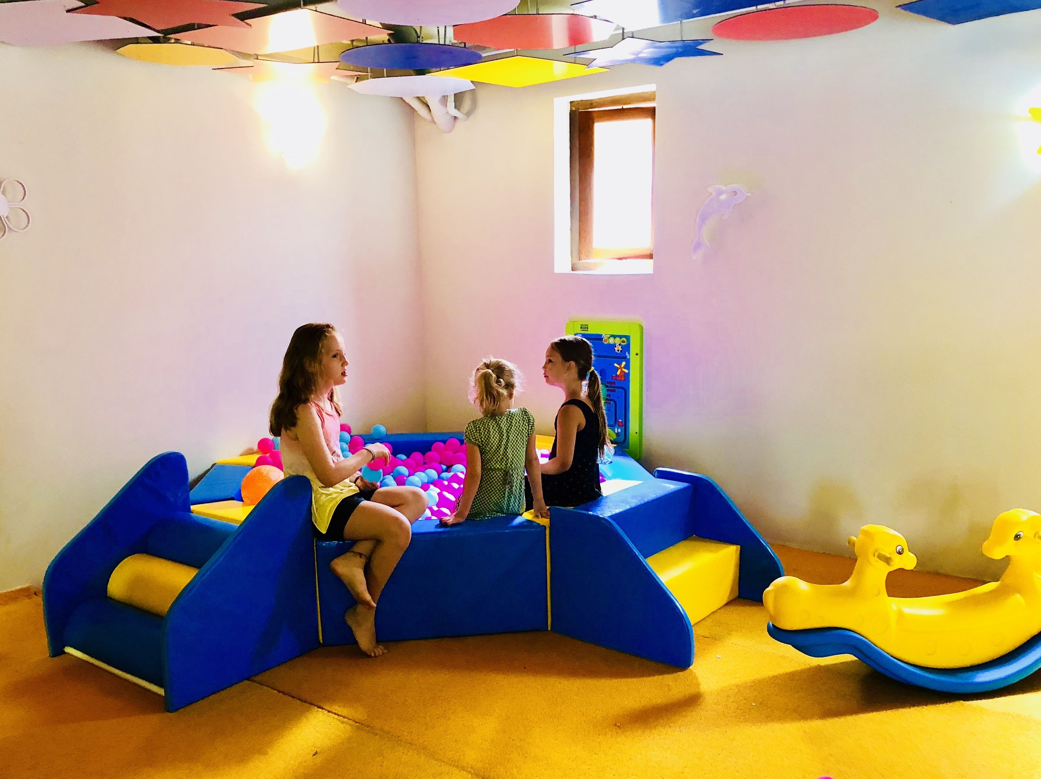 Zona de juegos con piscina de pelotas, tobogán y juguete con forma de pato.