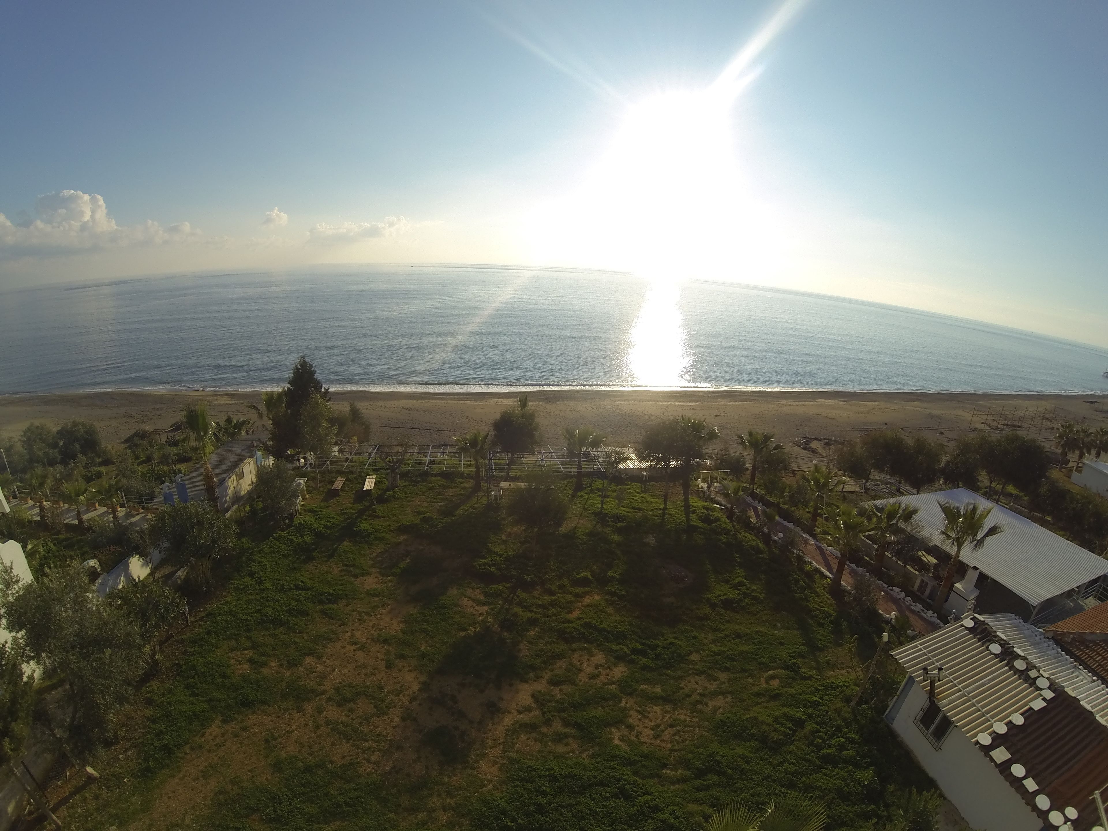 Eine Küstenlandschaft mit Strand, Vegetation und Gebäuden.