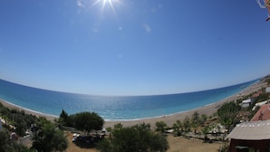 A beach view with clear skies, a sandy shore, and a few people in the distance. - Mavi Cennet Camping Pansiyon (Manavgat)