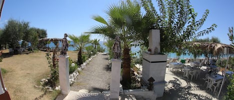 Un sendero que lleva a un área de estar al aire libre con vistas al mar.