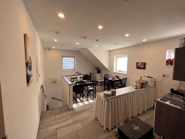 A compact kitchen with a dining area, a small refrigerator, and a microwave. - Penzion Hornička (Cesky Krumlov)