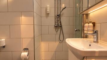 Moderni kylpyhuone, jossa on wc, pesuallas ja suihku.