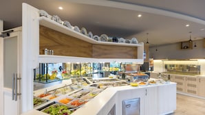 Ein Buffet mit verschiedenen Speisen und einem Holzregal darüber.