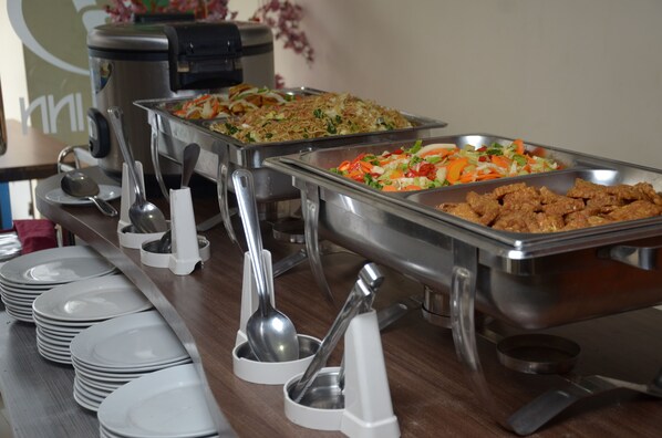 A buffet setup with various food dishes and serving utensils.