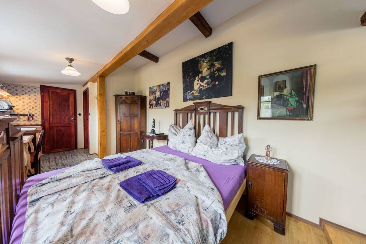 Quarto com cama de madeira, escrivaninha e guarda-roupa.