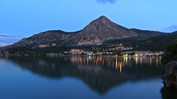 Una montaña reflejada en aguas tranquilas, rodeada de edificios.