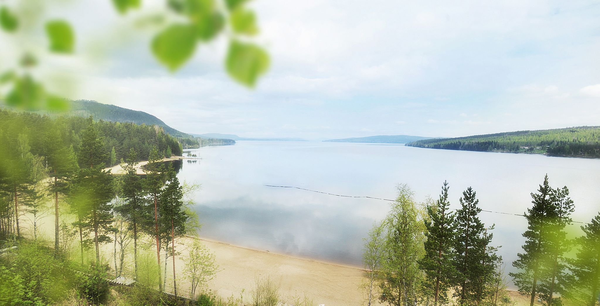 A lake surrounded by forested hills.