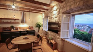 Una cocina moderna con vigas de madera, una pared de piedra, un amplio ventanal con vistas e horno empotrado.