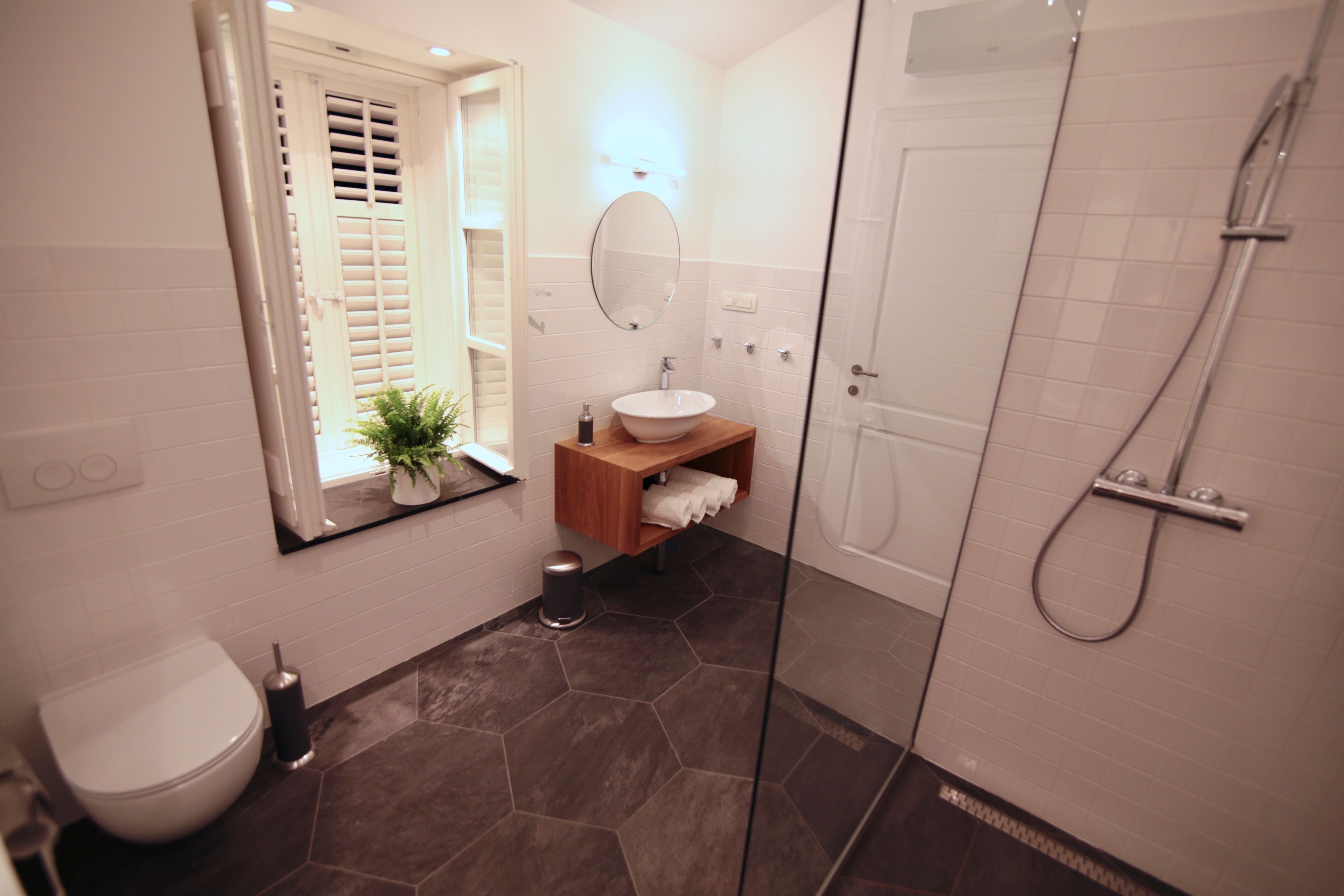 A modern bathroom with a toilet, sink, and shower.