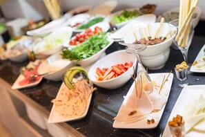 A buffet with various food items including sliced meats, vegetables, and dips. - The Fortyfive Business Hotel & Spa (Manisa)