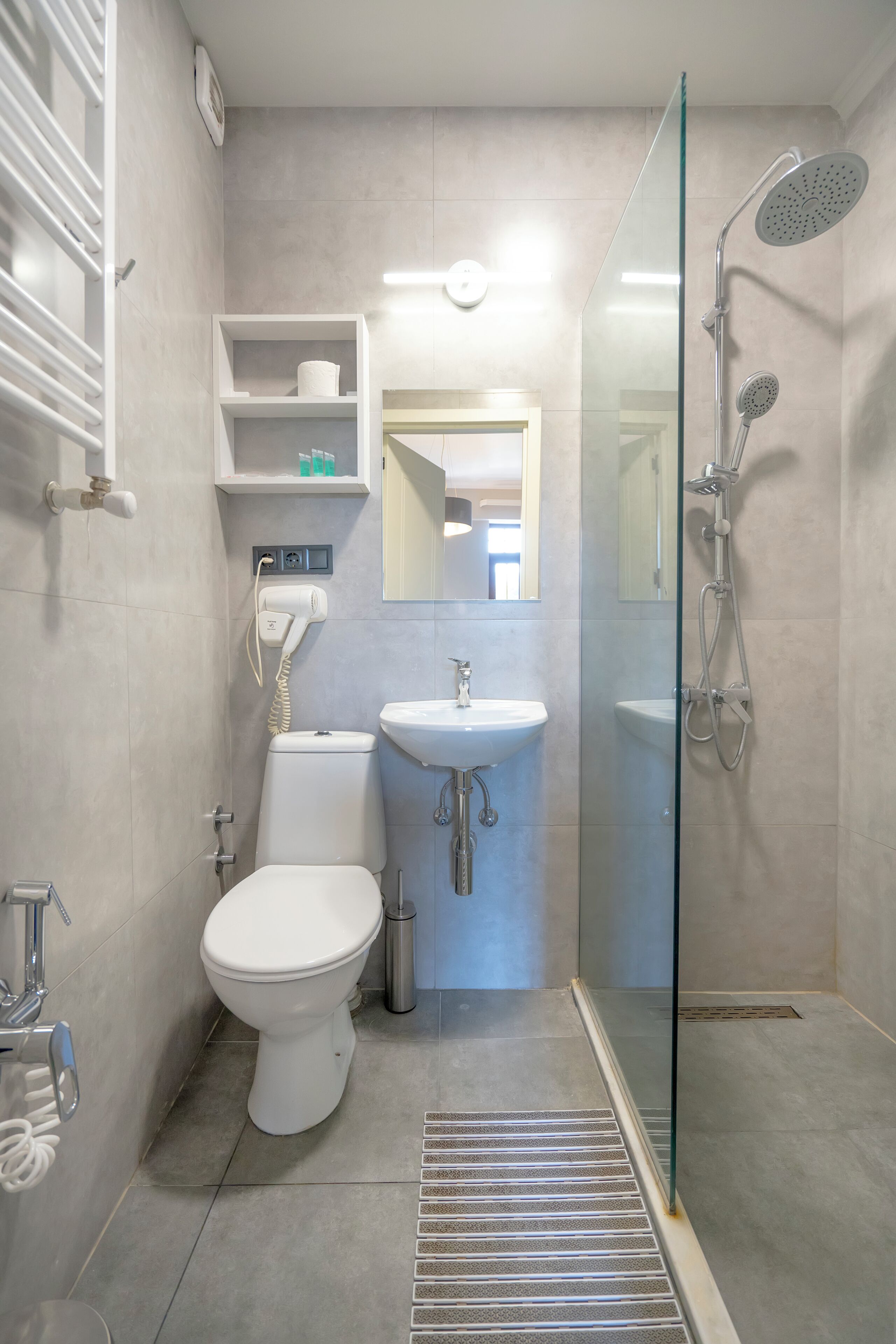 A modern bathroom with a toilet, sink, and glass-enclosed shower.